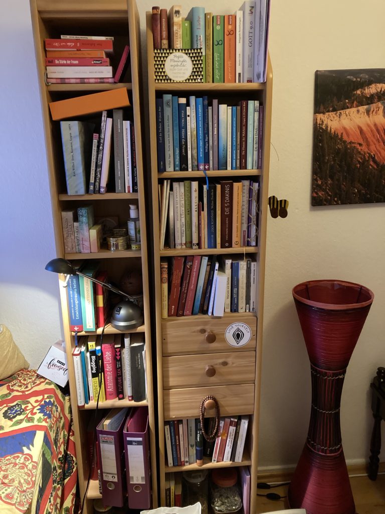 Bücherregal mit roter Lampe und Bild
